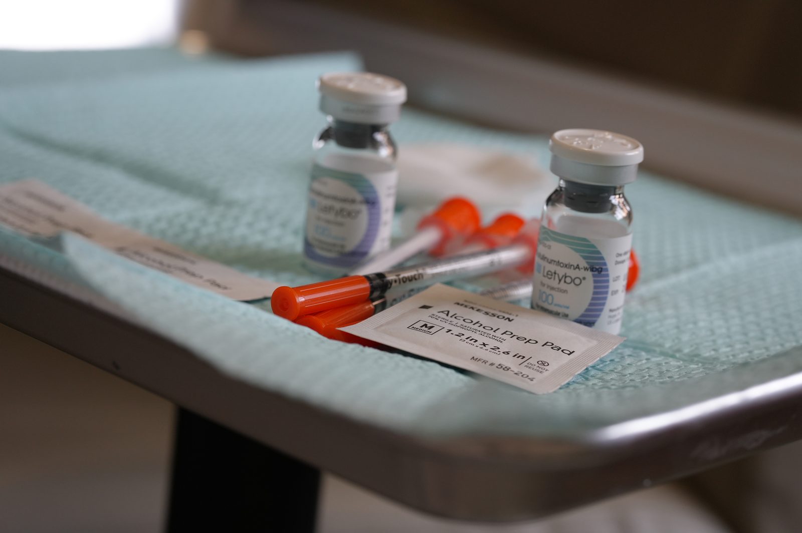 Two neurotoxin vials with insulin syringes and an alcohol prep pad on a treatment tray